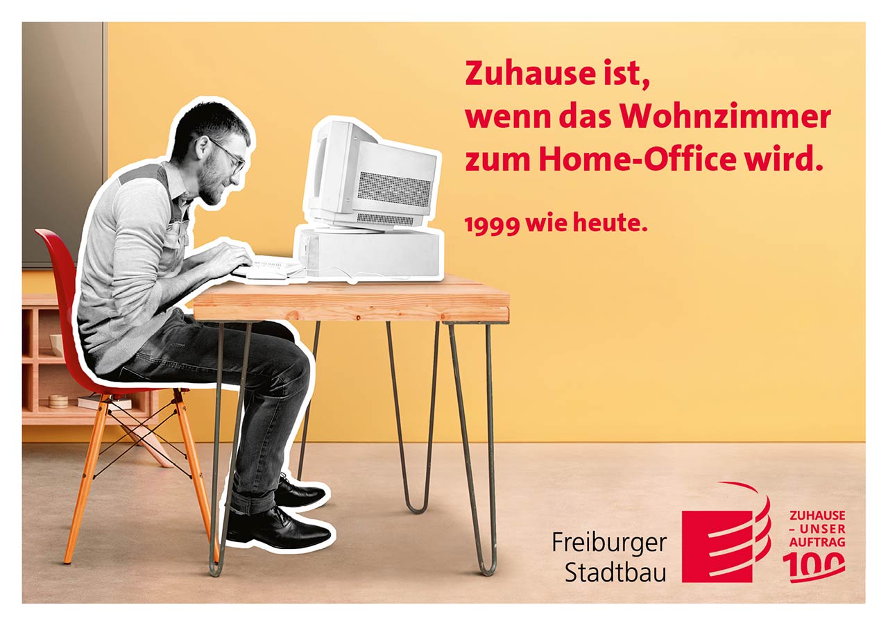 Das Foto ist eine Werbeanzeige mit Bezug auf das Wohnen im Jahr 1999. Es zeigt einen jüngeren Mann der am Tisch vor einem alten Computer mit Röhrenbildschirm sitzt. Der Slogan lautet: Zuhause ist, wenn das Wohnzimmer zum Home-Office wird. 