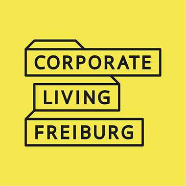 Das Logo von Corporate Living Freiburg, welches einen gelben Hintergrund mit schwarzen Schriftzug hat