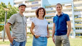 Kooperationspartner beim Pilotprojekt Balkonsolar: (v.l.n.r.) Arne Blumberg von der Energieagentur Regio Freiburg, Nadine Maisenhölder von der f.q.b. (Freiburger Qualifizierungs- und Beschäftigungsgesellschaft mbH) und Axel Zimmermann von der Freiburger Stadtbau. Im Hintergrund: Balkonsolaranlagen in der Krozinger Straße